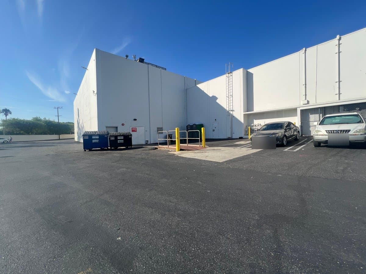 Loading dock and dumpster enclosure area behind a retail building on a Guardian trash and debris route